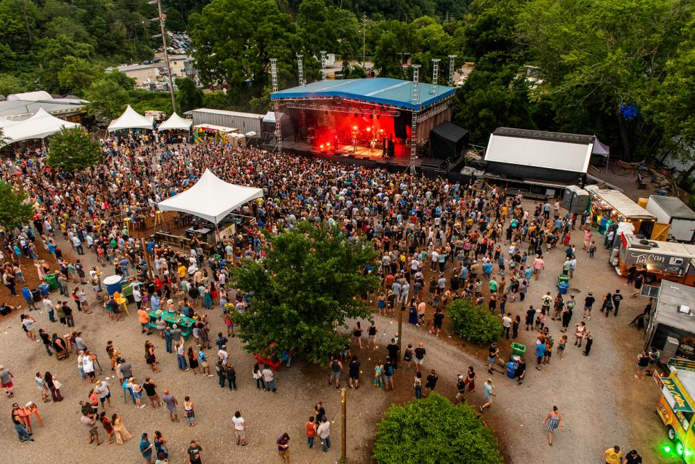 Aerial photo of a crowd surrounded outside near a stage at Salvage Station